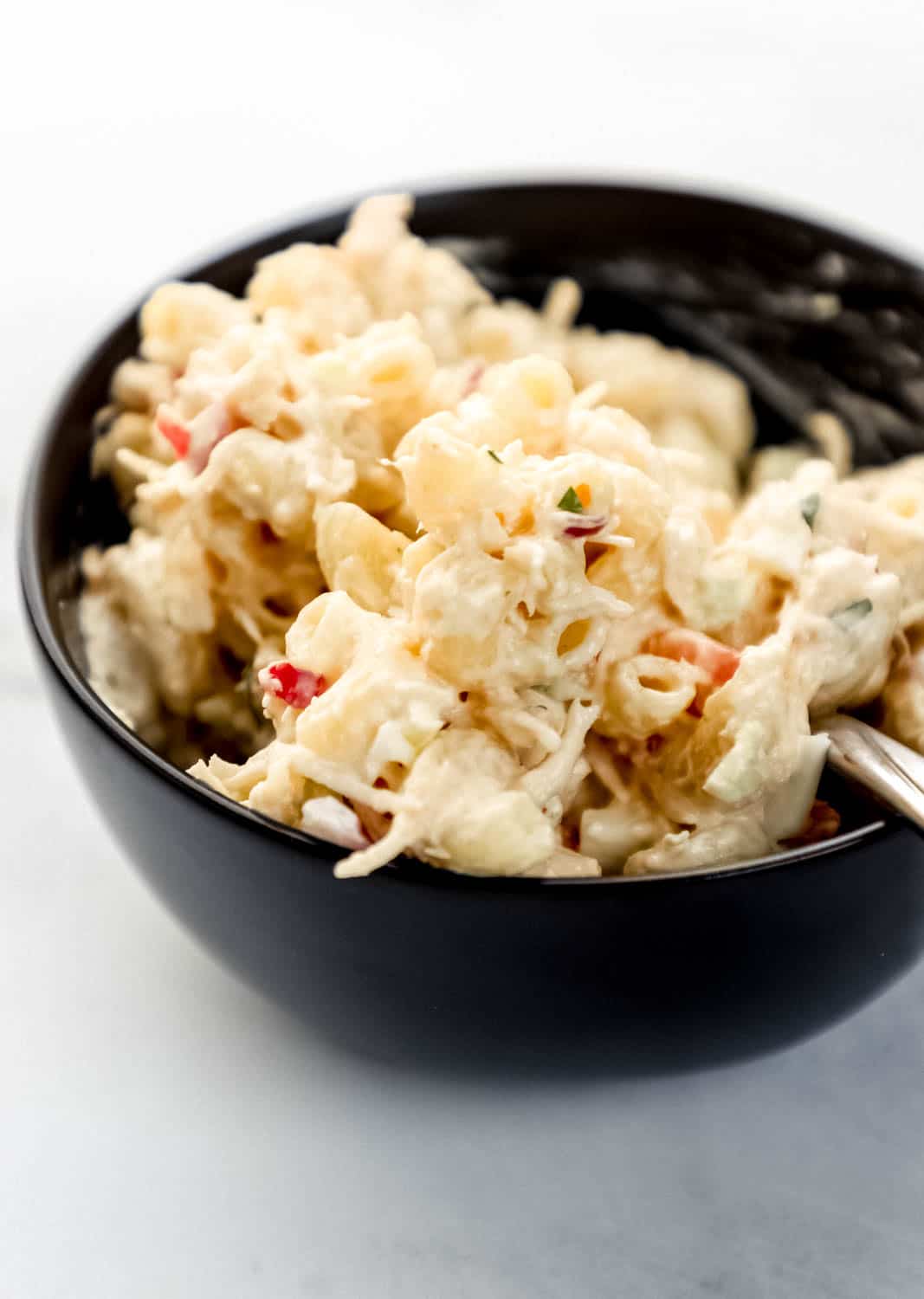 Close up side view of small black bowl with pasta and fork in it. 
