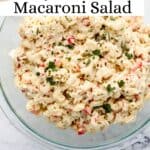 Overhead view of pasta salad in large glass bowl topped with parsley on pin with text overlay.