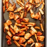 Overhead view of sheet pan with finished chicken nuggets and french fries on it.