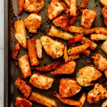 Close up overhead view of finished nuggets and fries on sheet pan.