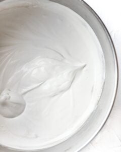 Condensed milk added to heavy cream in mixing bowl.
