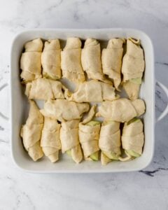 Apple slices rolled in dough and place in baking dish.