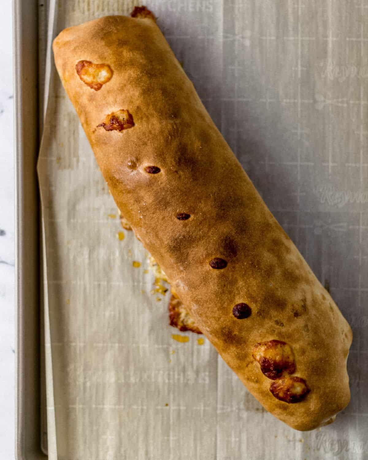 Overhead view of baked bread on parchment lined baking sheet. 