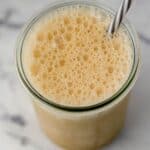 Close up overhead view of finished drink in glass with a straw.