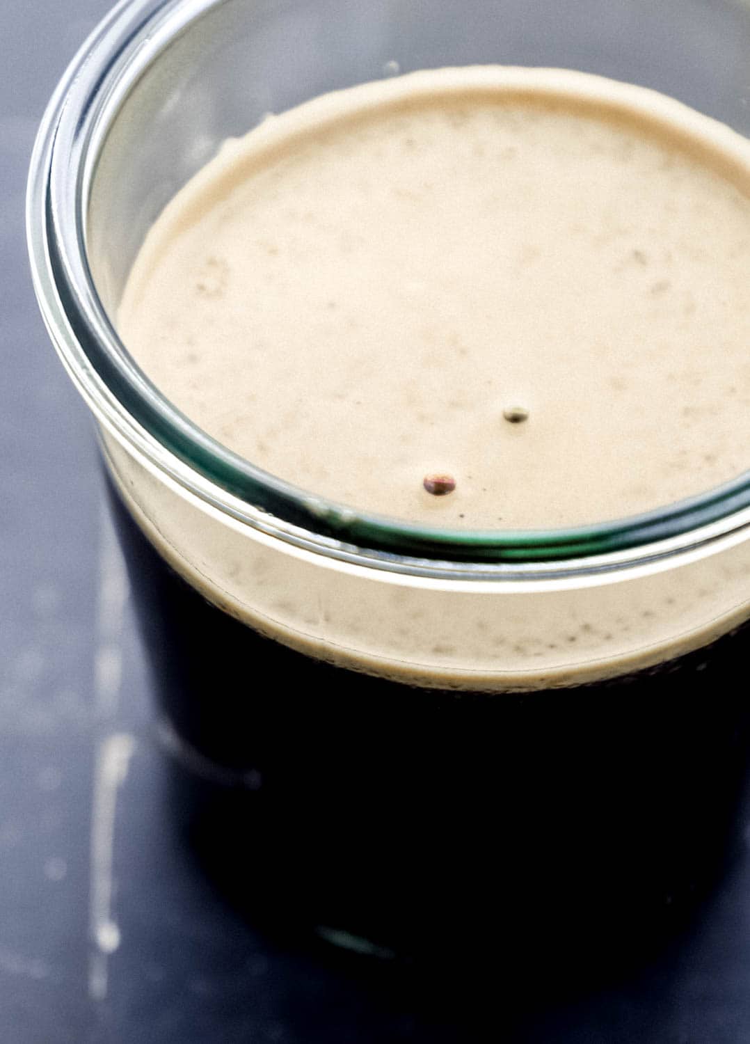 Close up side view of finished sauce in glass jar. 