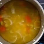 Overhead view of large pot of soup before straining.