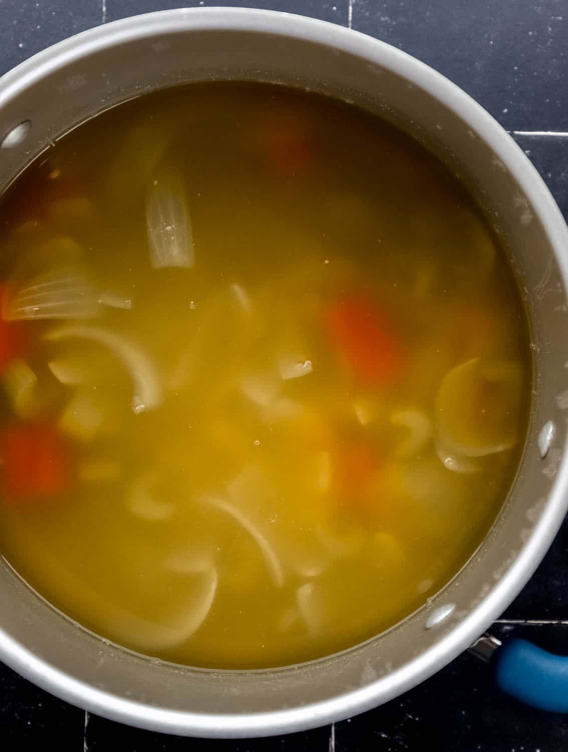Overhead view of hibachi soup in large pot before straining. 