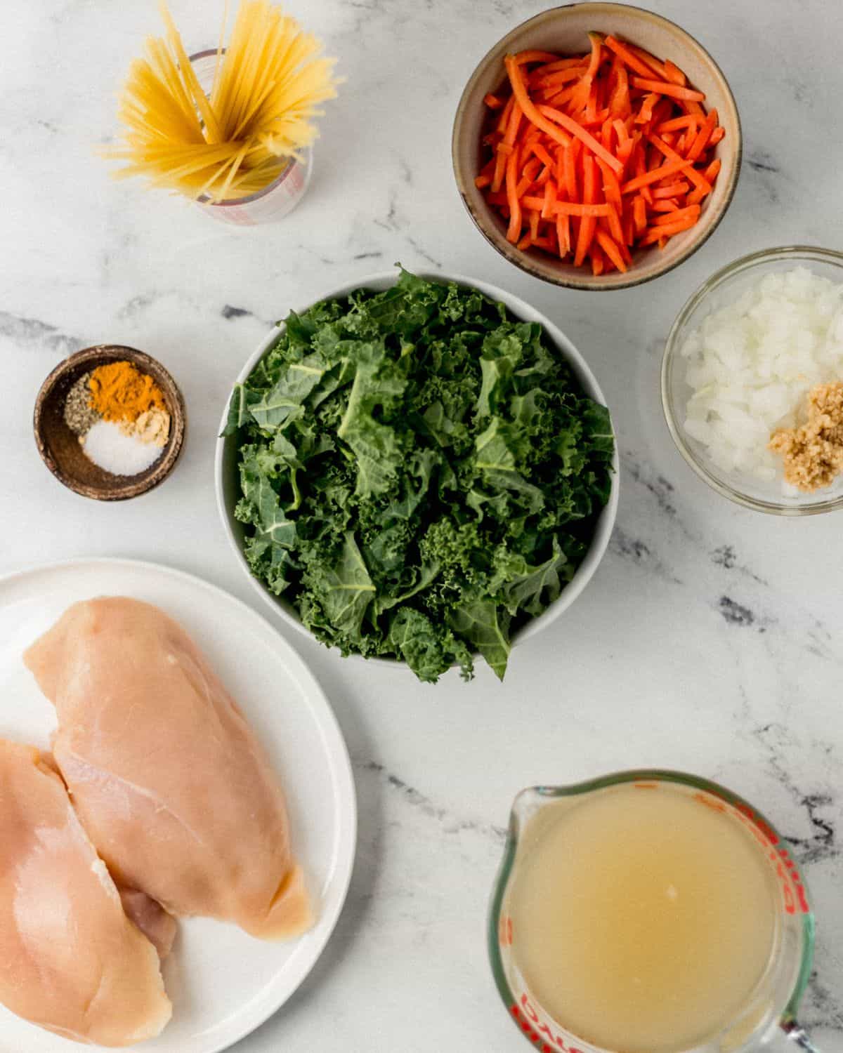 Overhead view of ingredients needed to make soup in separate bowls. 