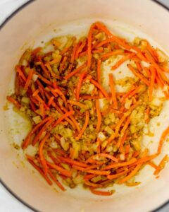 Close up view of carrots and onion in dutch oven