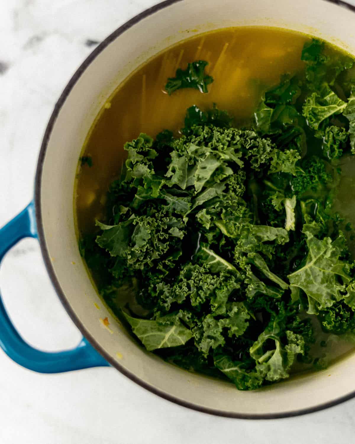 Noodles and fresh kale added to the pot with the other soup ingredients. 