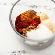 Close up front view of seasonings in a glass bowl.