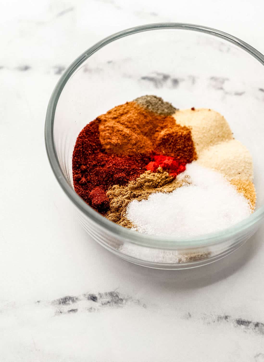 Close up front view of seasonings in a glass bowl. 