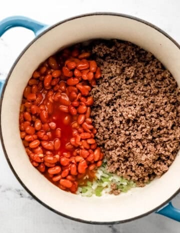Bean and ground beef added to dutch oven with veggies.