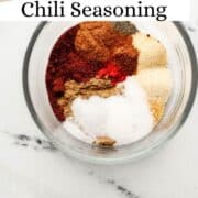 Ingredients to make chili seasoning in glass bowl on pin with text overlay.