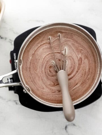 Sauce ingredients combined in saucepan with whisk.