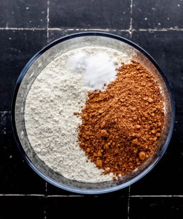 Dry cake ingredients added to a glass mixing bowl.