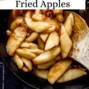Overhead view of apples in cast iron skillet with wooden spoon on pin with text overlay.
