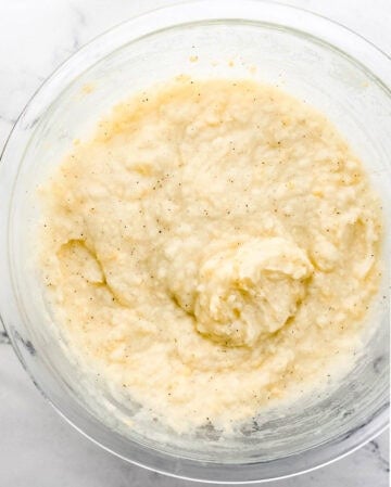 Overhead view of mashed potatoes in large glass mixing bowl.