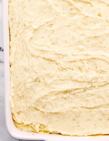 Mashed potatoes added to the top of the beef mixture in the baking dish.
