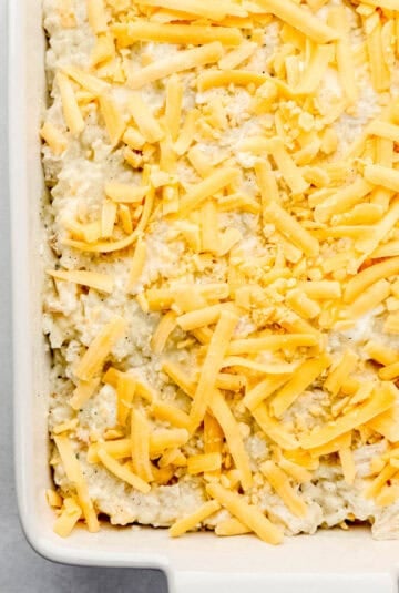 Casserole topped with shredded cheese before baking.