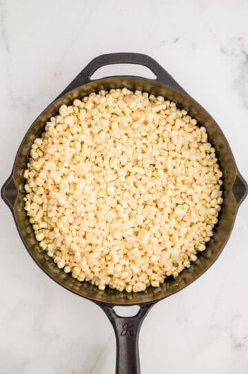 Corn added to cast iron skillet.