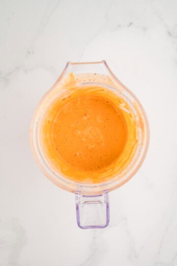 Overhead view of dressing ingredients combined in blender.