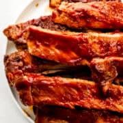 Close up view of finished ribs on white plate.
