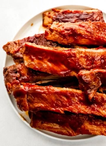Close up view of finished ribs on white plate.