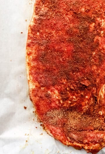 Ribs rubbed in spice blend on parchment paper.