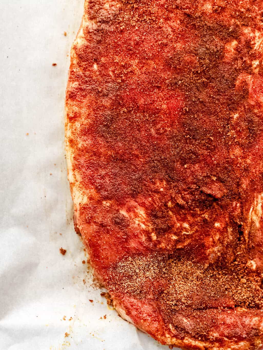 Dry rub added to the ribs on parchment paper. 