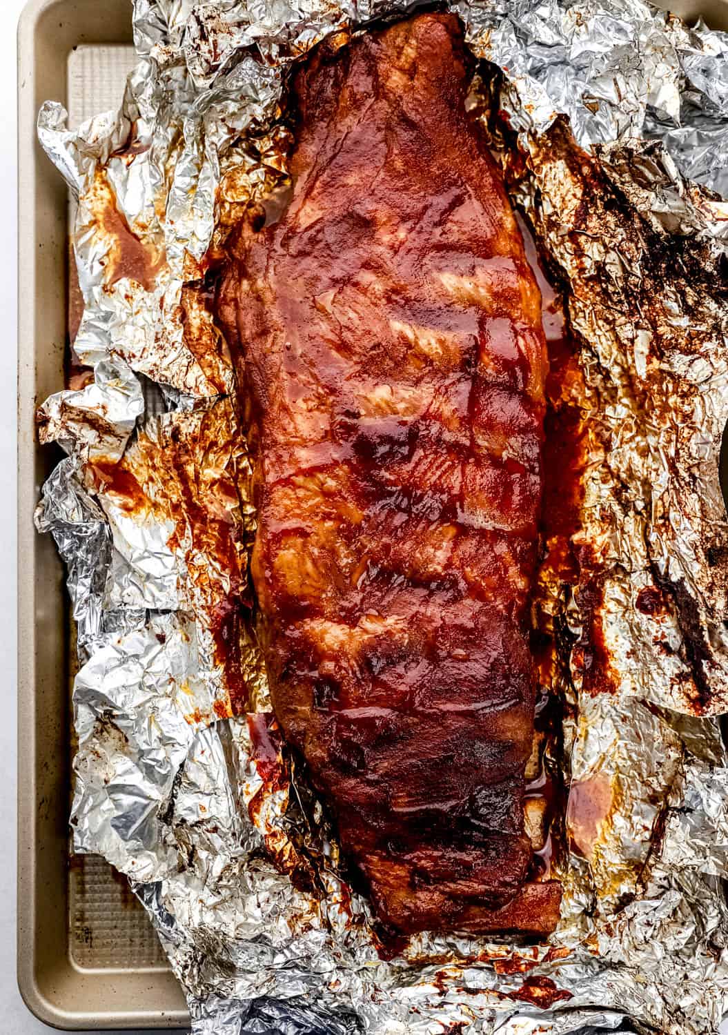 Overhead view of finished ribs on top of foil on sheet pan. 