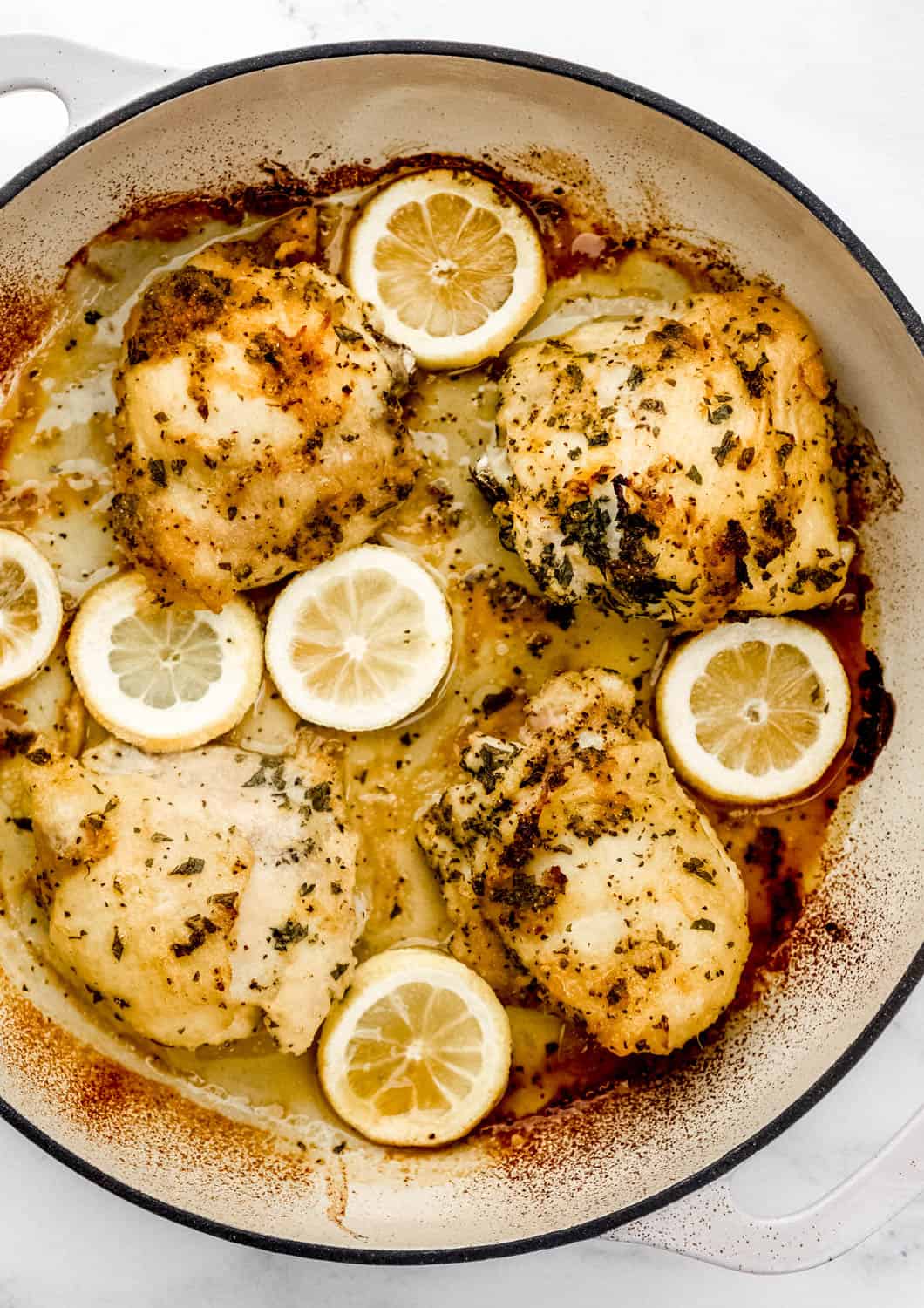 Overhead view of baked chicken in braiser pan. 