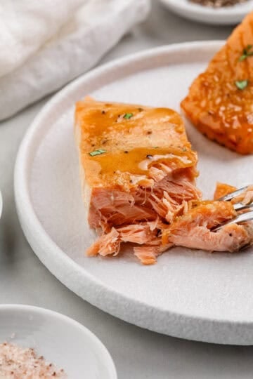 Close up view of salmon on plate with fork.