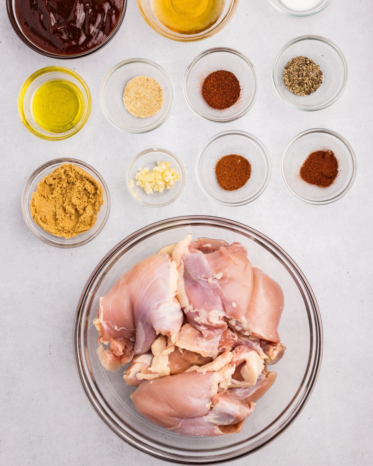 Overhead view of ingredients needed to make chicken in separate bowls. 
