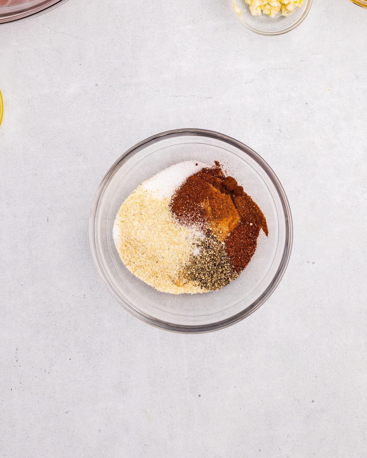 Spice ingredients added to small glass bowl. 