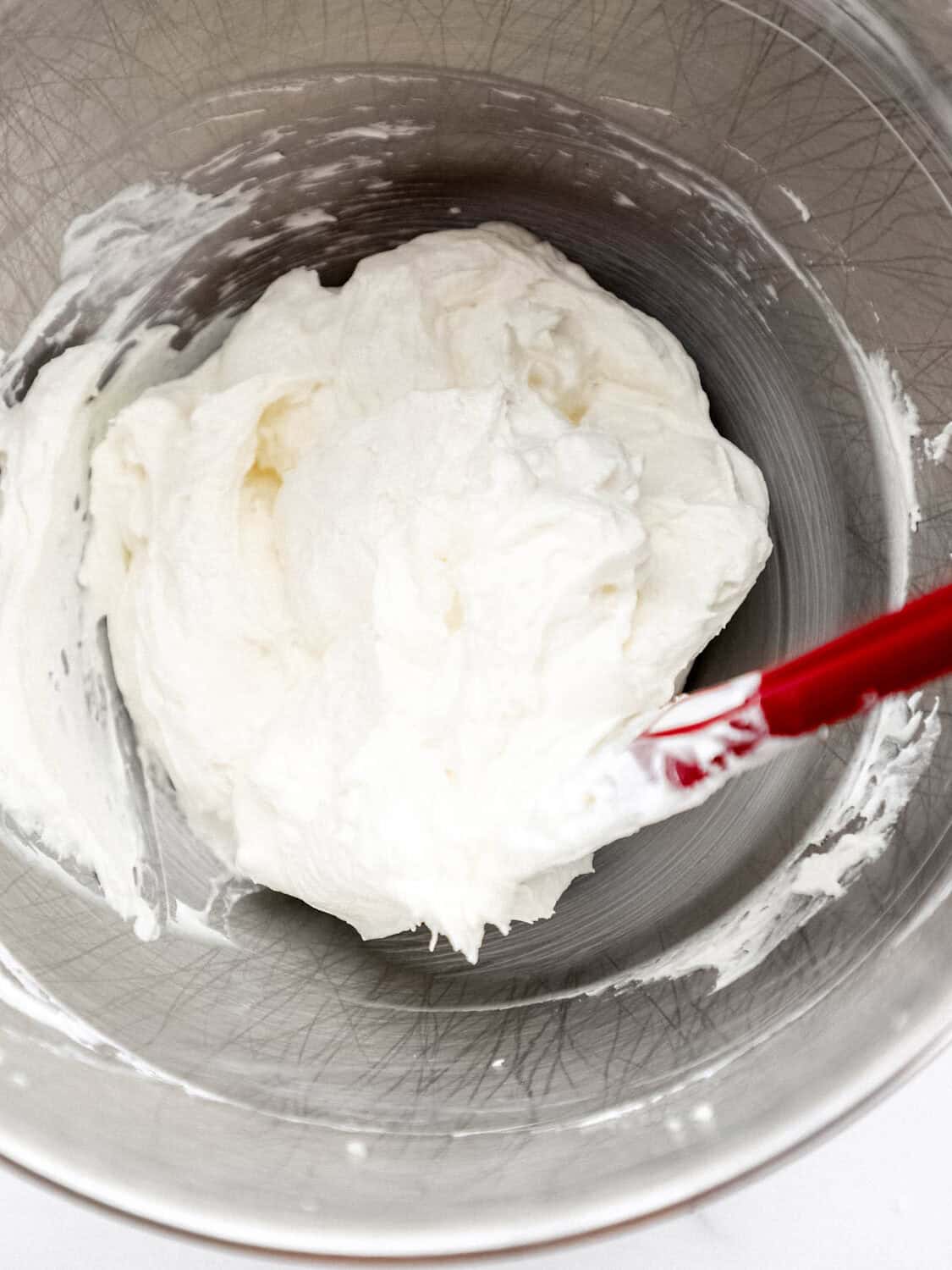 Cream cheese layer ingredients combined in mixing bowl with rubber spatula. 