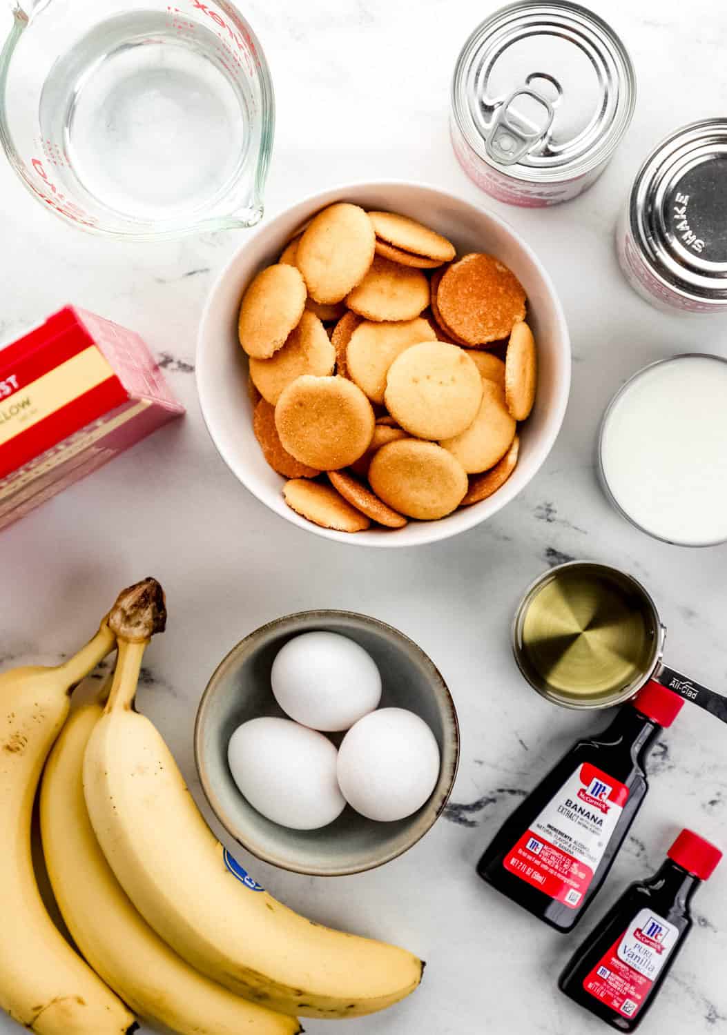 Overhead view of ingredients needed to make cake in separate bowls on marble surface.
