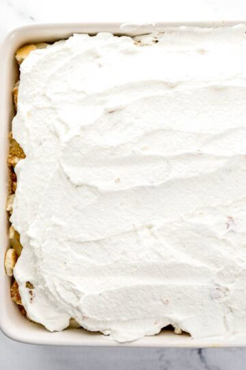 Cake topped with bananas and whipped cream.
