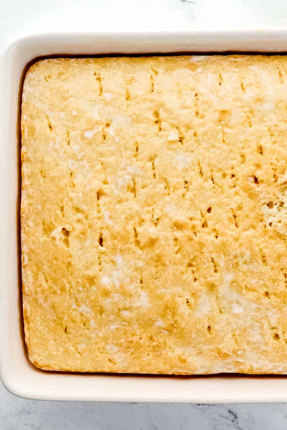 Milk mixture added to the cake in baking dish.
