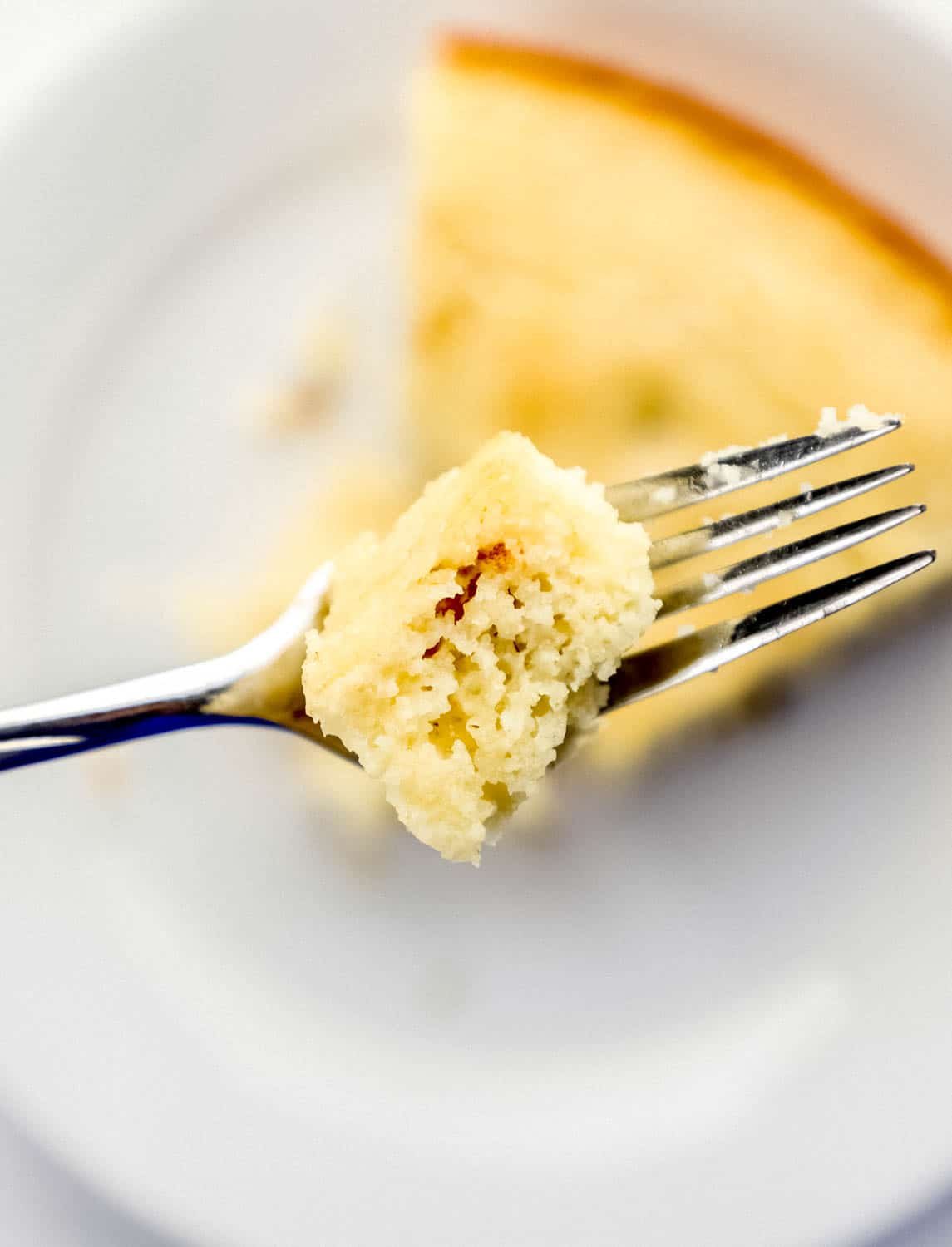 Close up of fork with piece of finished cornbread on it. 