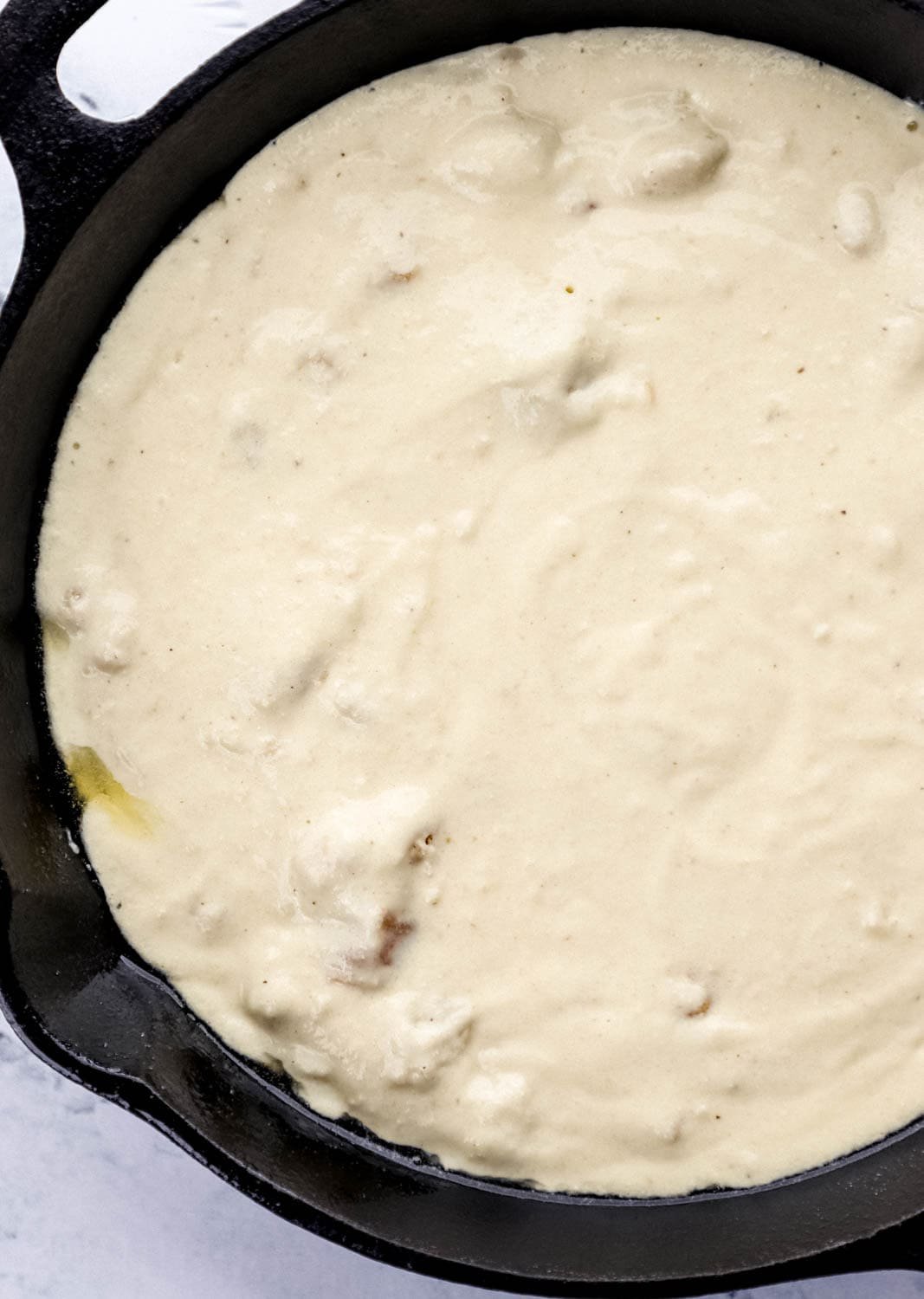 Cornbread mixture added to cast iron skillet. 