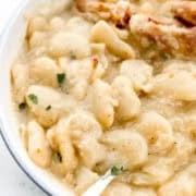 Close up front view of bowl of beans with fork in it.