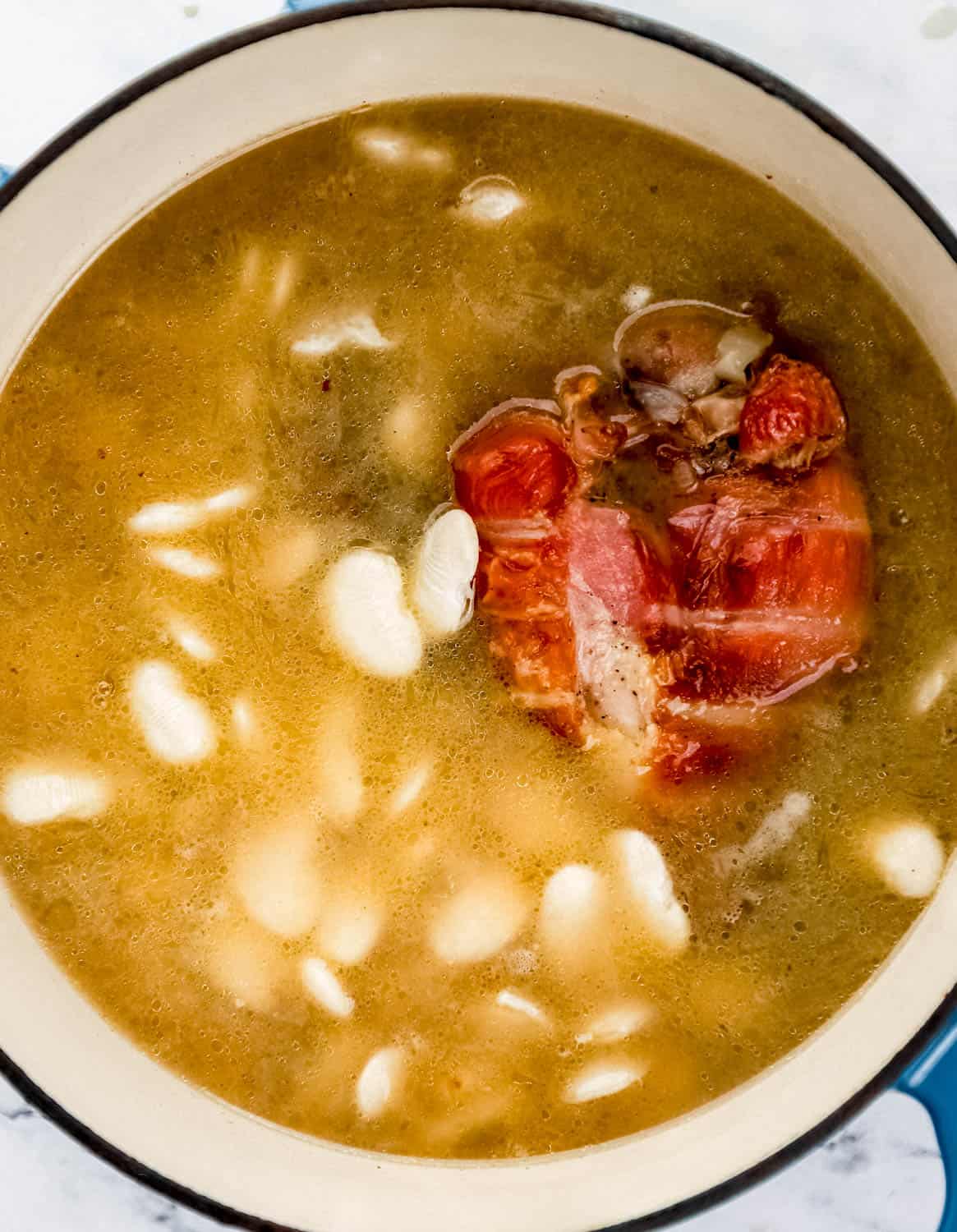 Beans added to other ingredients in the pot.