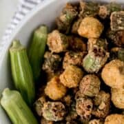 Fried okra in a white bowl on pin with text overlay.