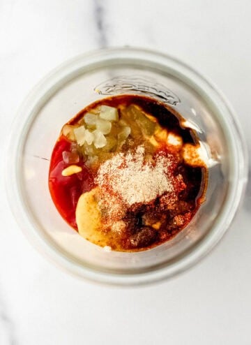 Overhead view of sauce ingredients added to a jar.