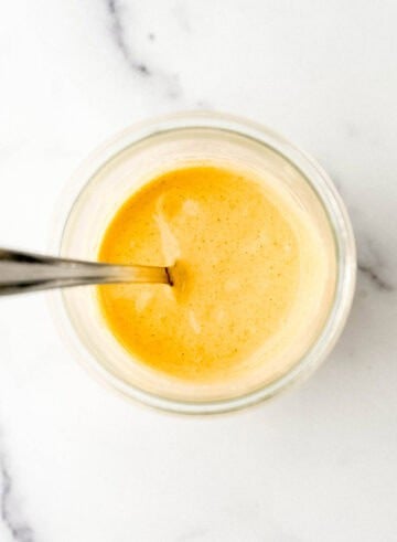 Overhead view of jar of sauce with spoon in it.