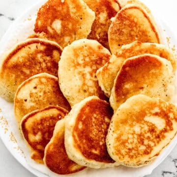 Overhead view of finished hoe cakes on paper towel lined plate.