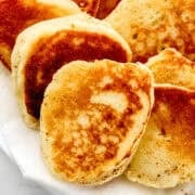 Close up view of hoe cakes on paper towel lined plate.