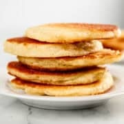 Close up side view of stack of cakes on plate.