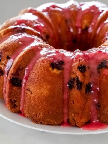 Close up side view of pound cake on white plate.